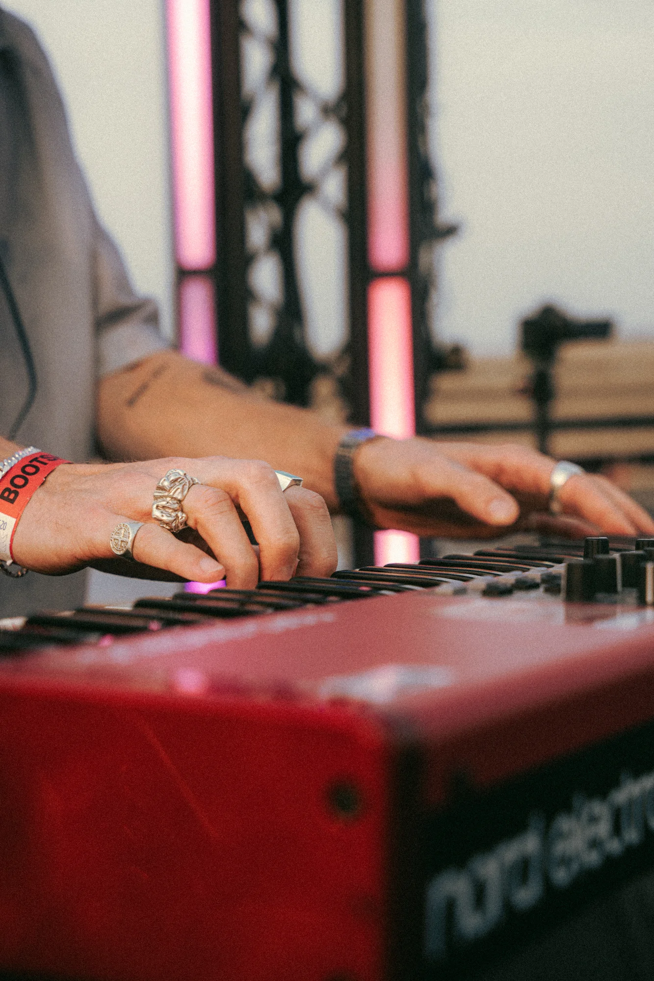 Detail der Hände am Keyboard im rosa Bühnenlicht