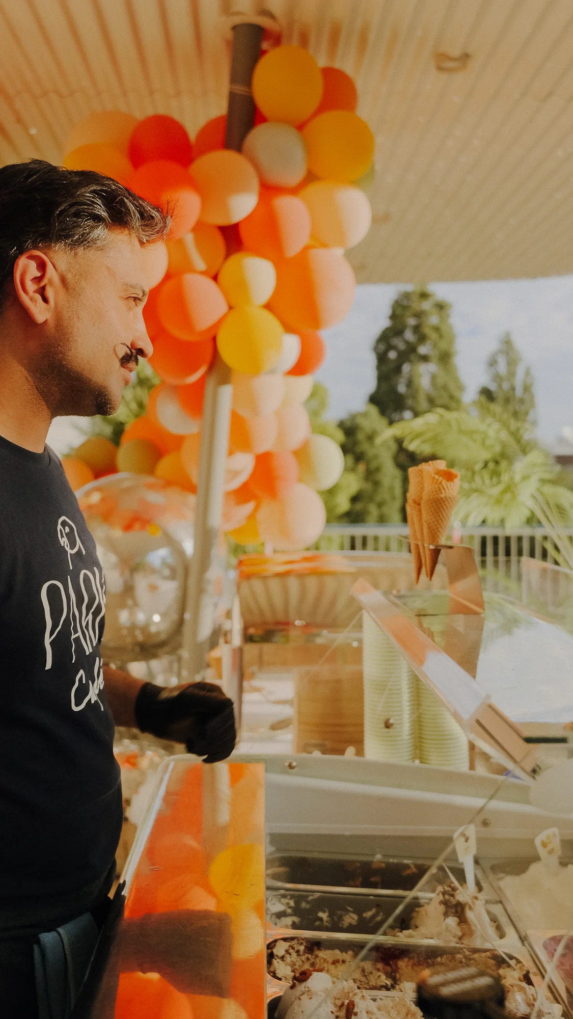Eisstand mit orangefarbenen und gelben Luftballons