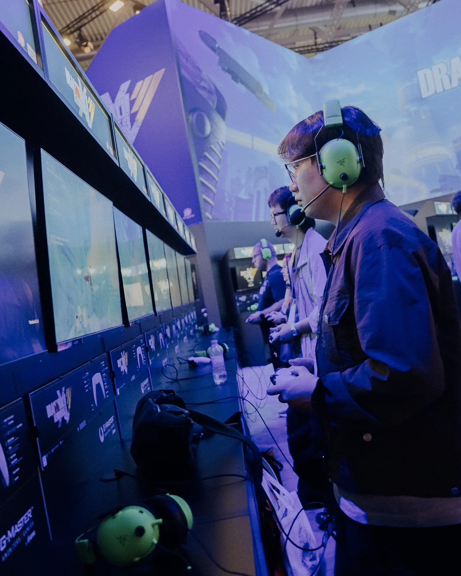 Spieler mit grünen Headsets im blauen Messelicht