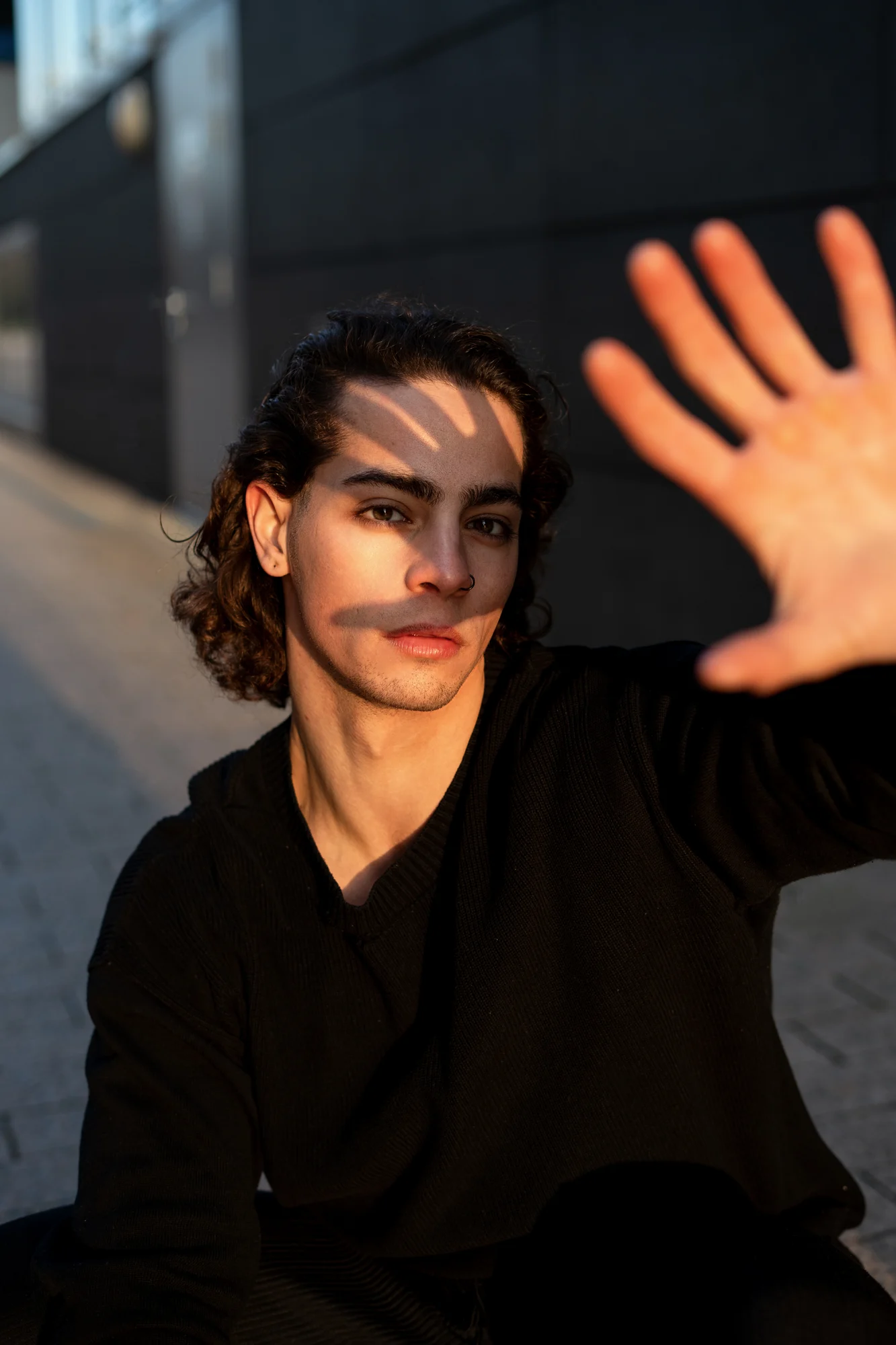 Porträt mit erhobener Hand und Schattenspiel im Gesicht