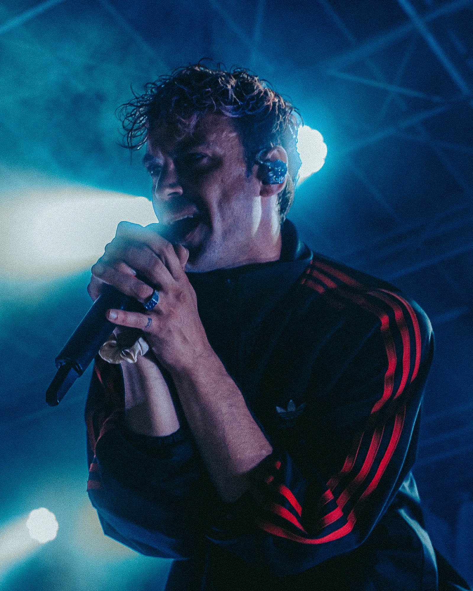 Lostboy Lino singt im blauen Gegenlicht in Nahaufnahme