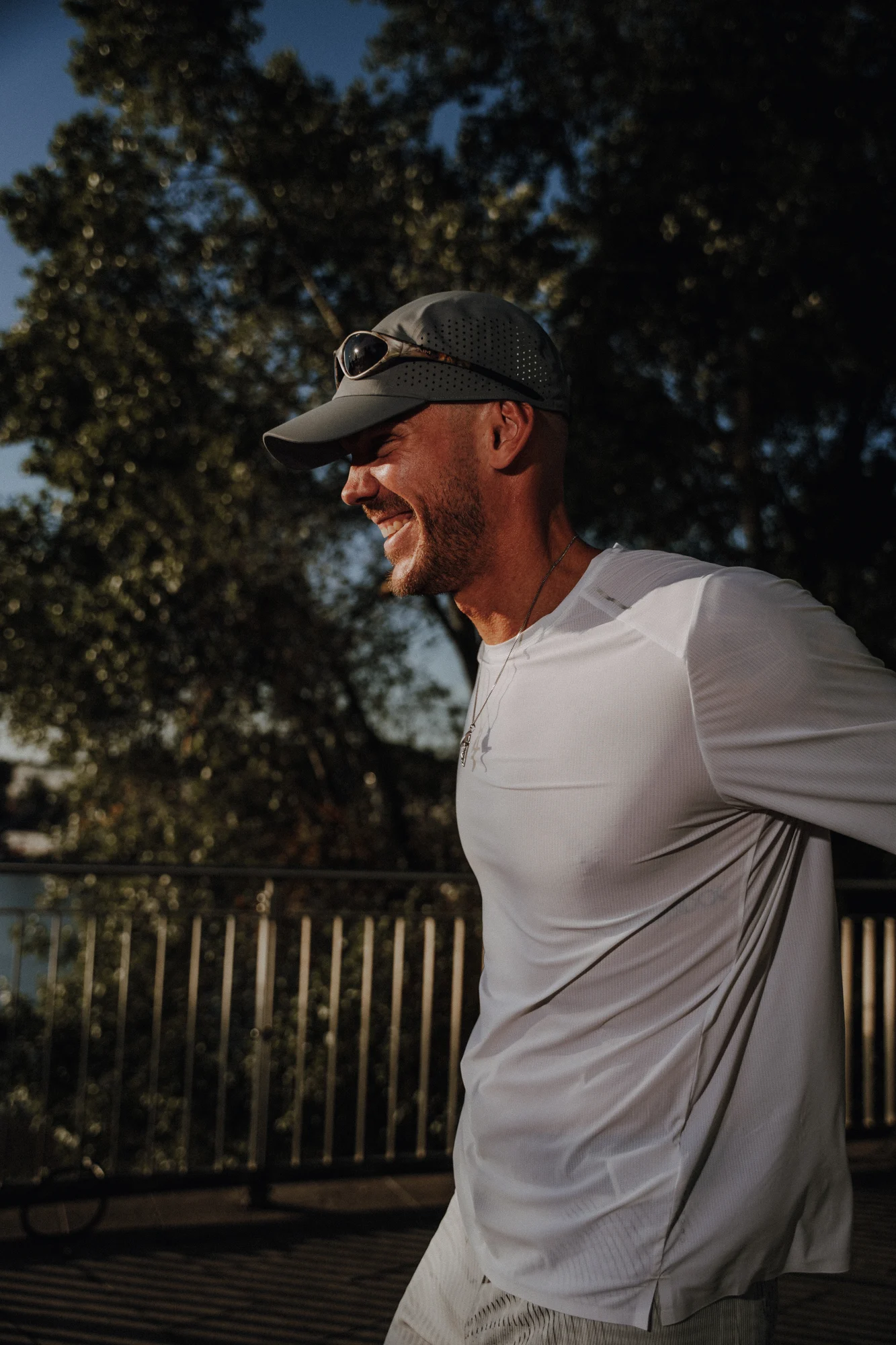 Lachender Athlet mit Laufcap im warmen Sonnenlicht