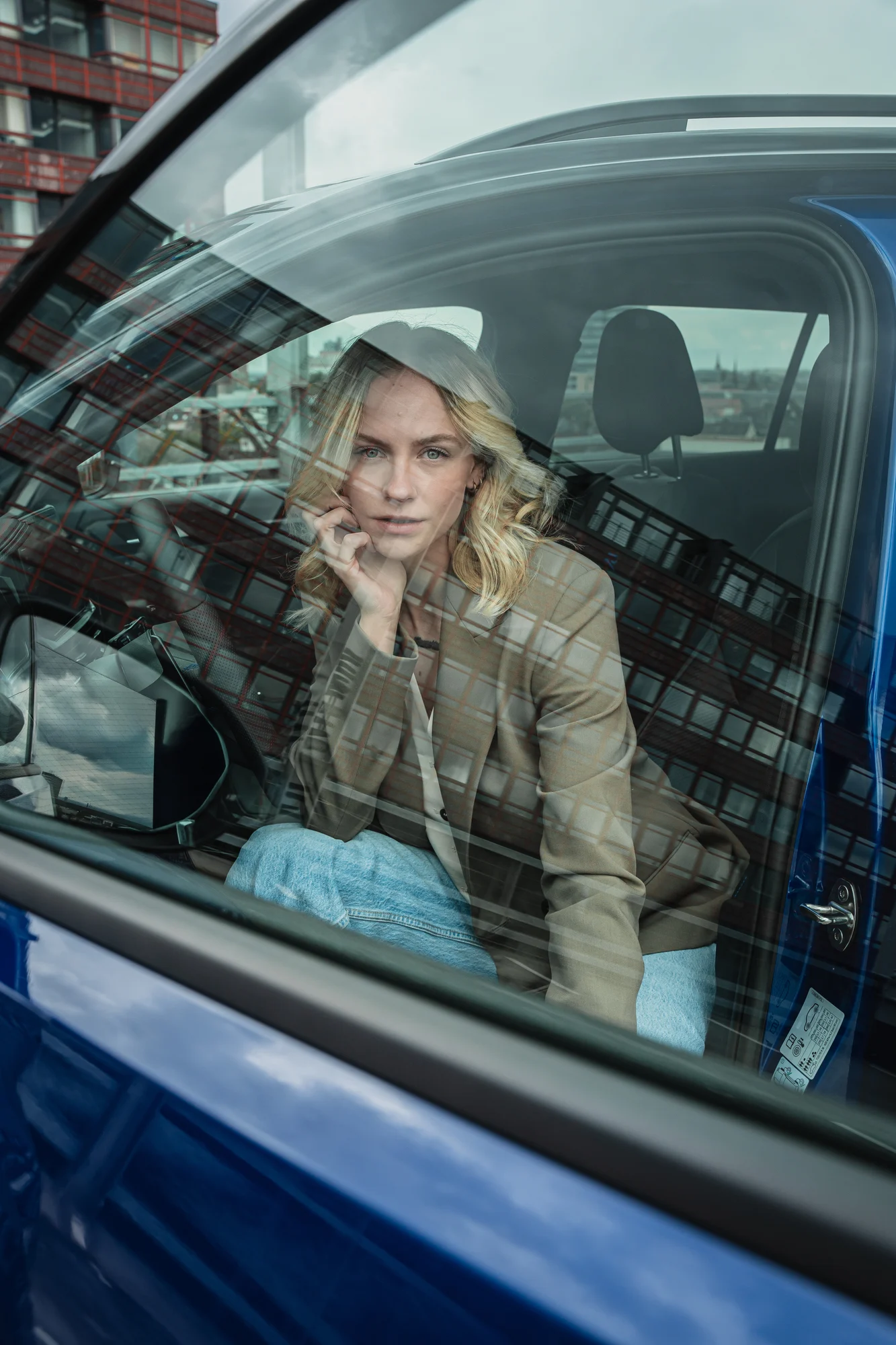 Porträt durch eine Autotür mit Spiegelungen der Stadt